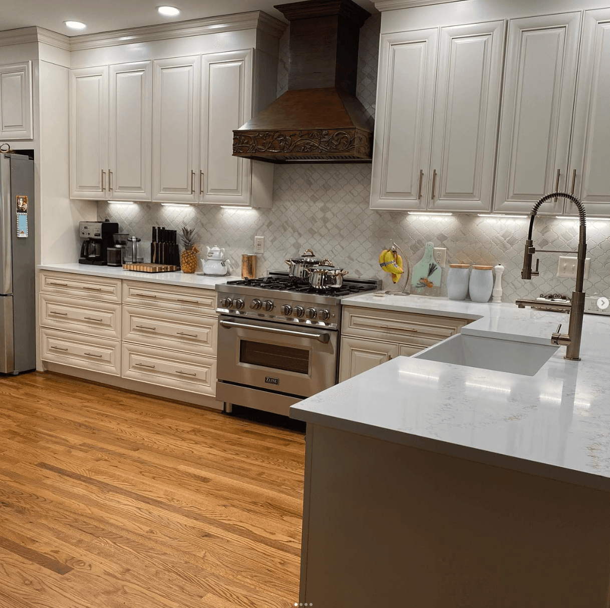 East Cobb, GA · Cream raised-panel kitchen with custom carved walnut range hood.