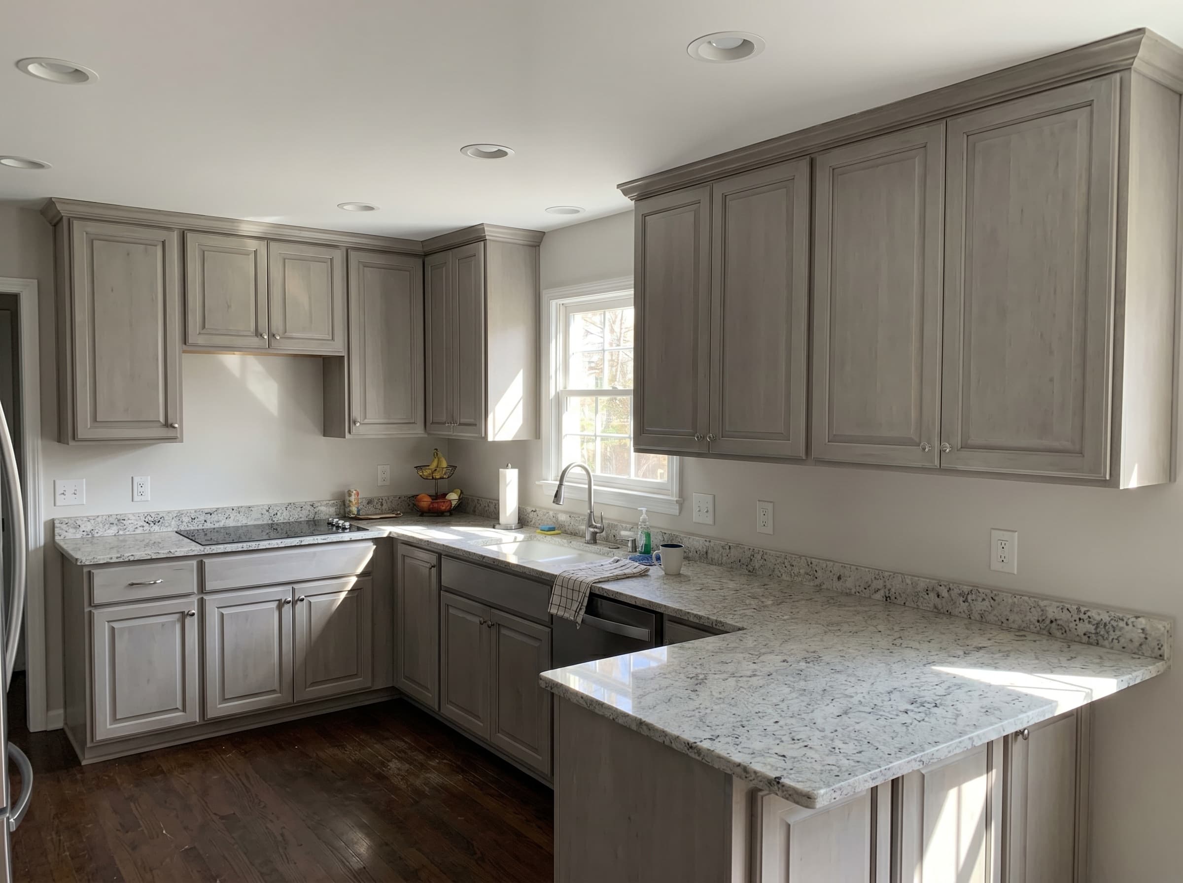 Marietta, GA · Light gray shaker kitchen with white granite countertop and dark hardwood floor.