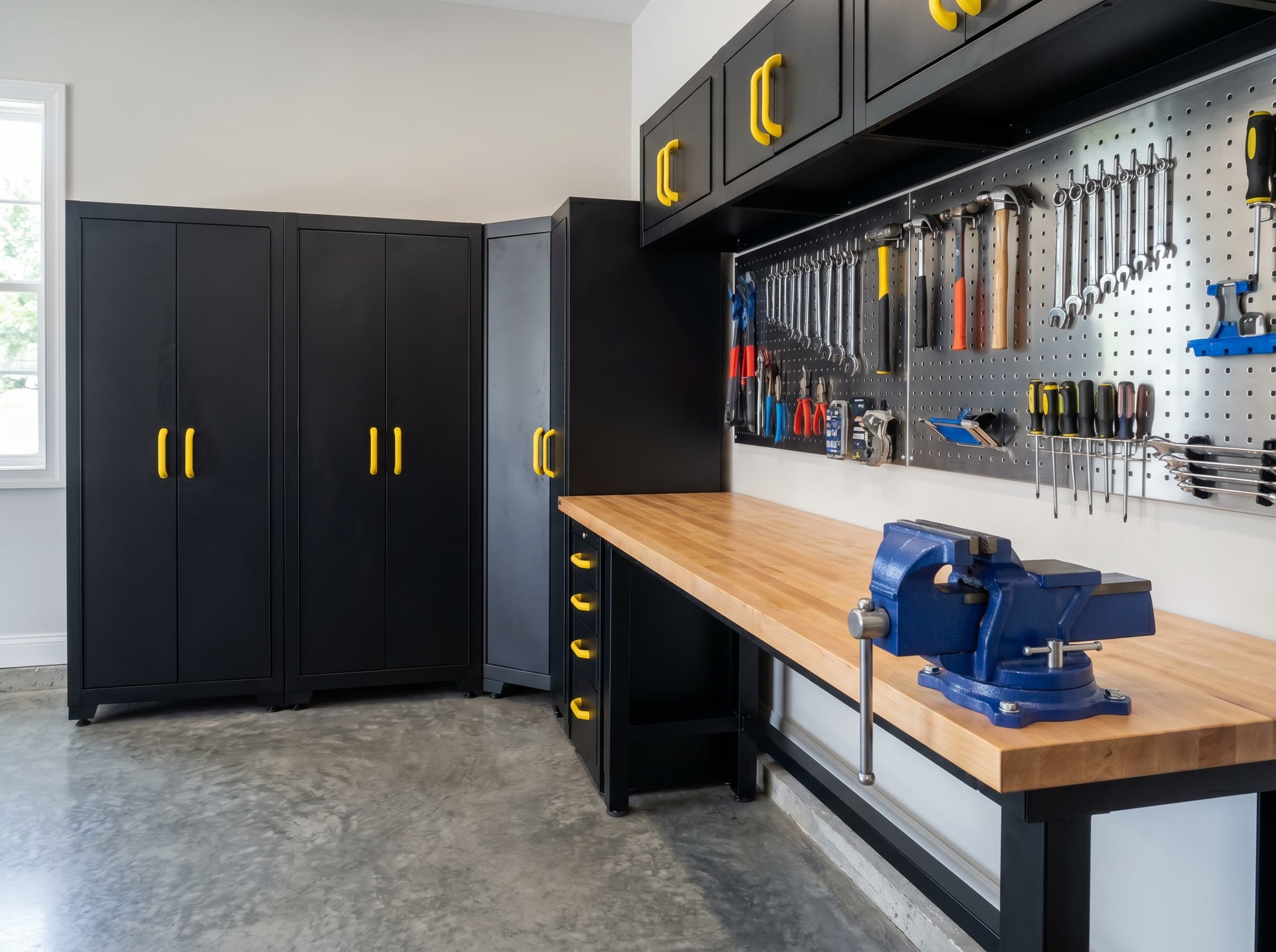 Woodstock, GA · Workshop corner with yellow-handled black cabinets and vise.