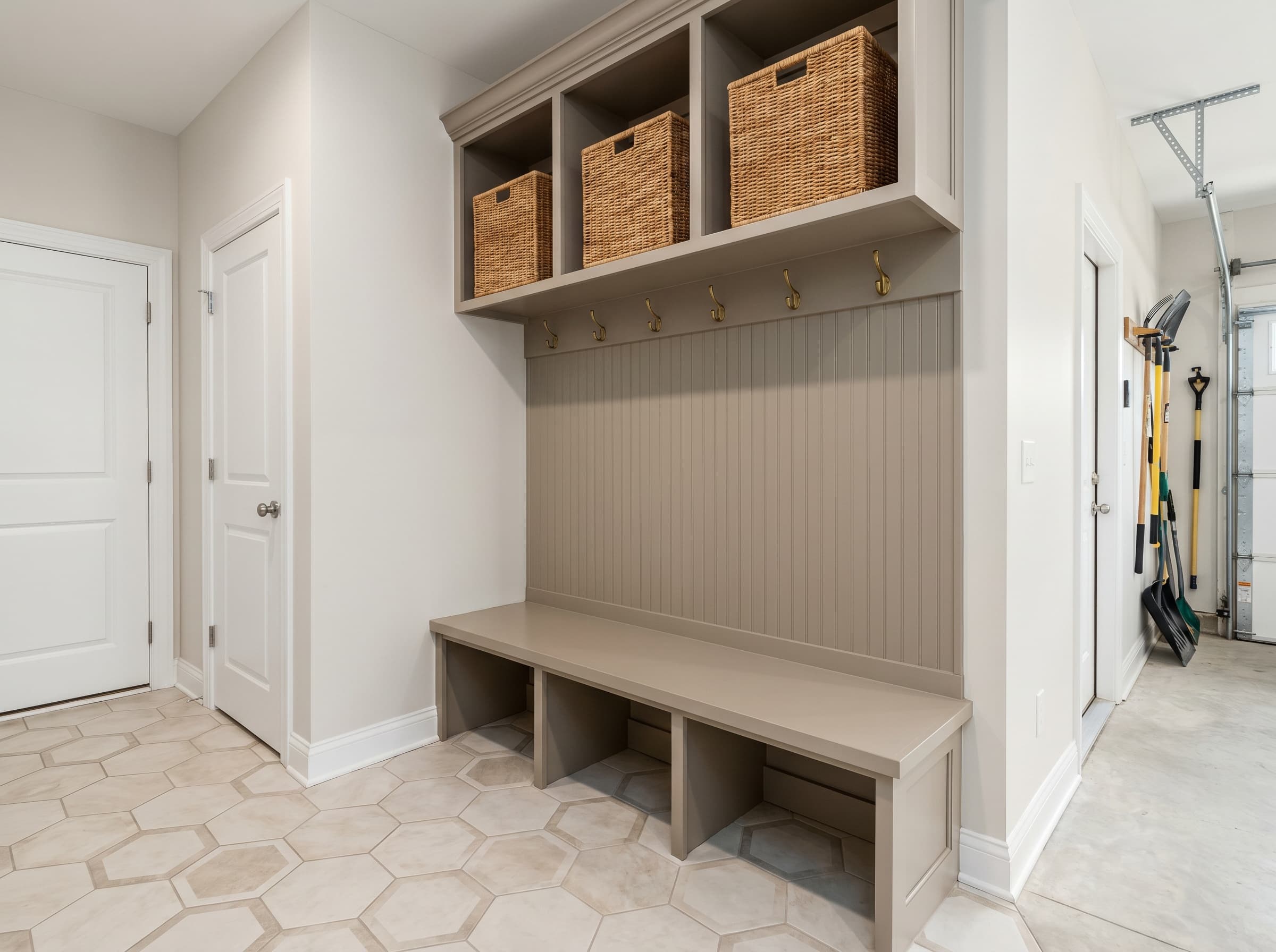 Buford, GA · Garage-entry mudroom with greige bench and beadboard wall.